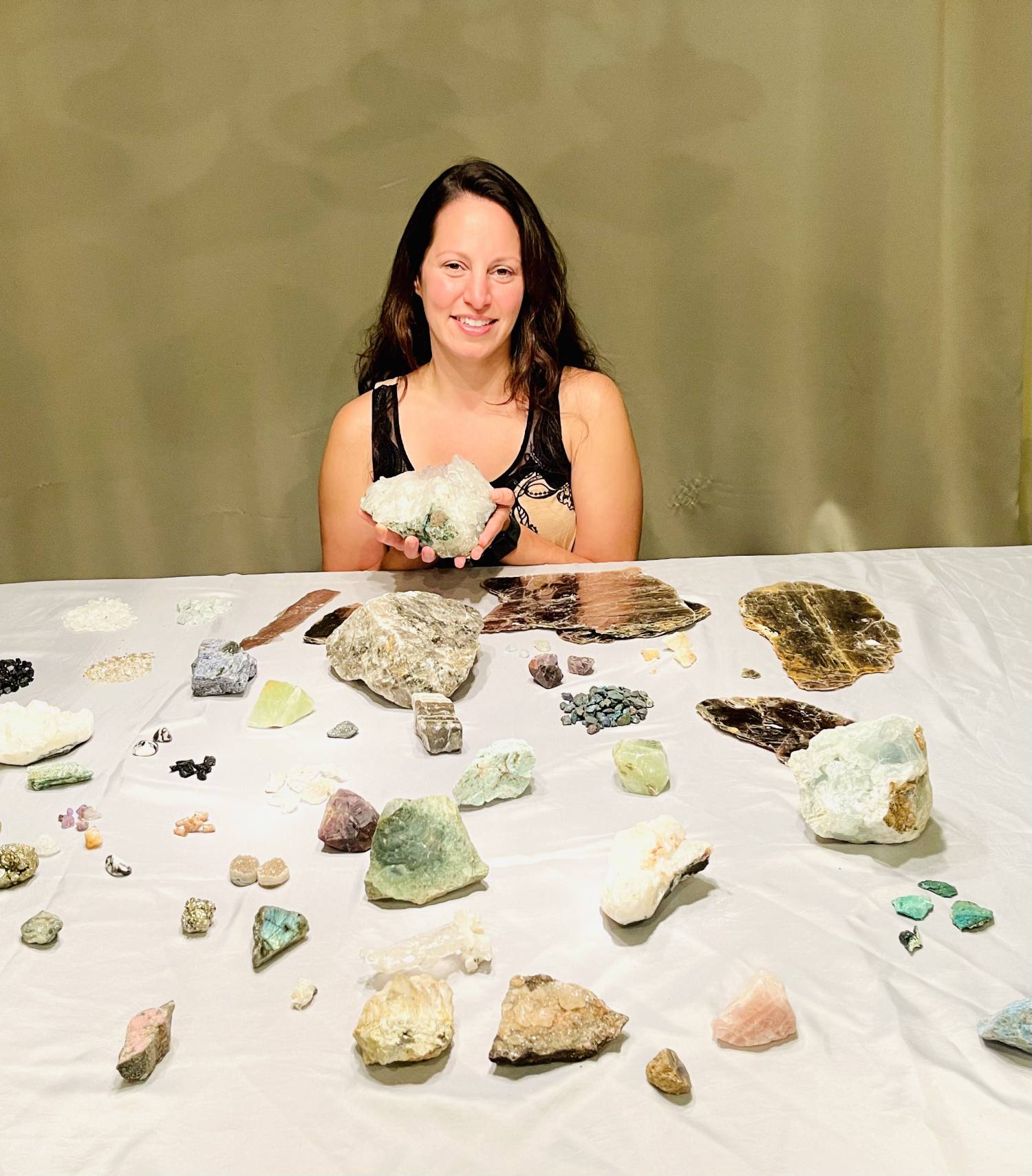 Tammy Campbell sitting at a table with uncut minerals and gemstones.